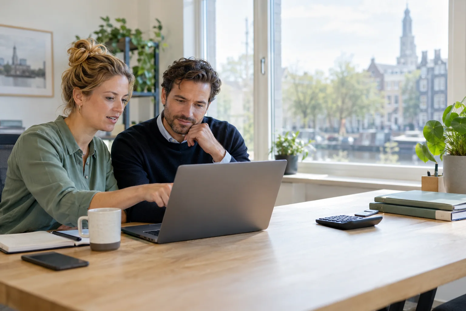 Een ondernemer en boekhouder bekijken samen de financi?le administratie op een laptop.